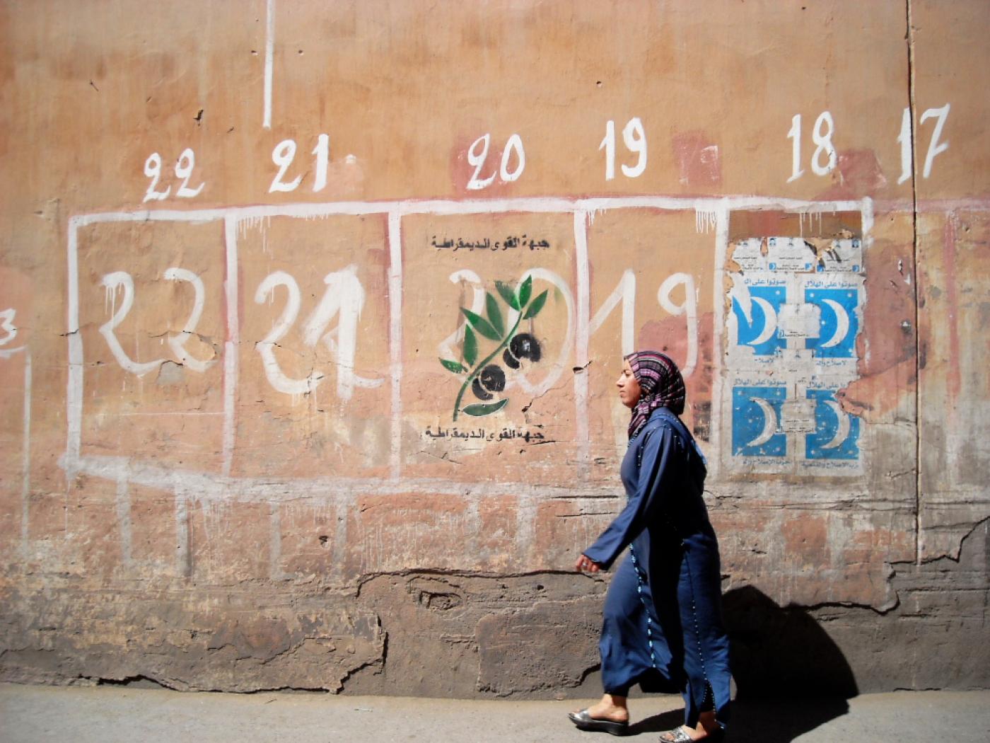 A woman walks past a sign for an election in Marrakesh, Morocco