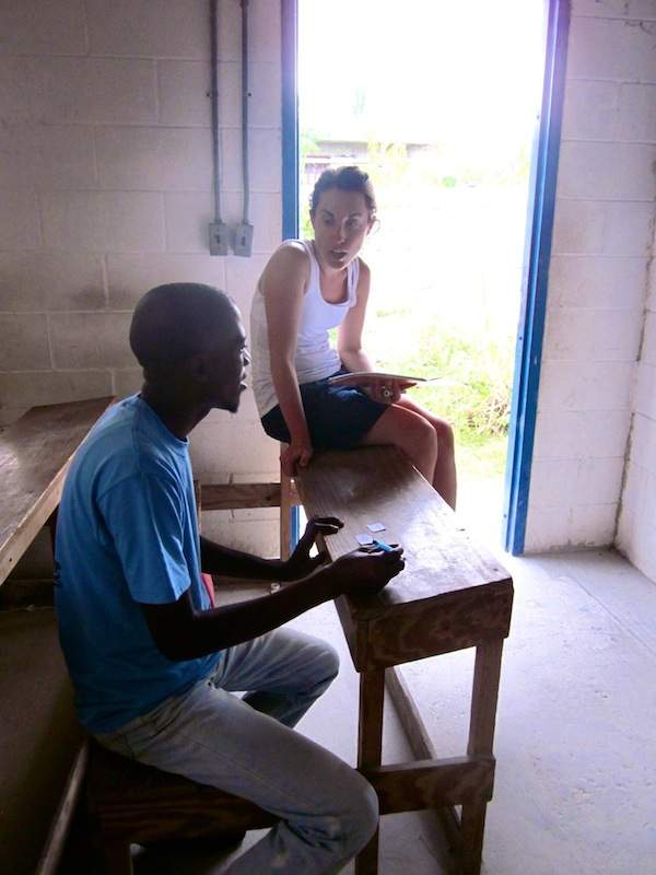 Natalie explains the difference between comparatives and superlatives to Robinson, one of her students, in beginner English class.