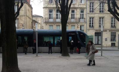 A tram arriving at a stop in Bordeaux, France.