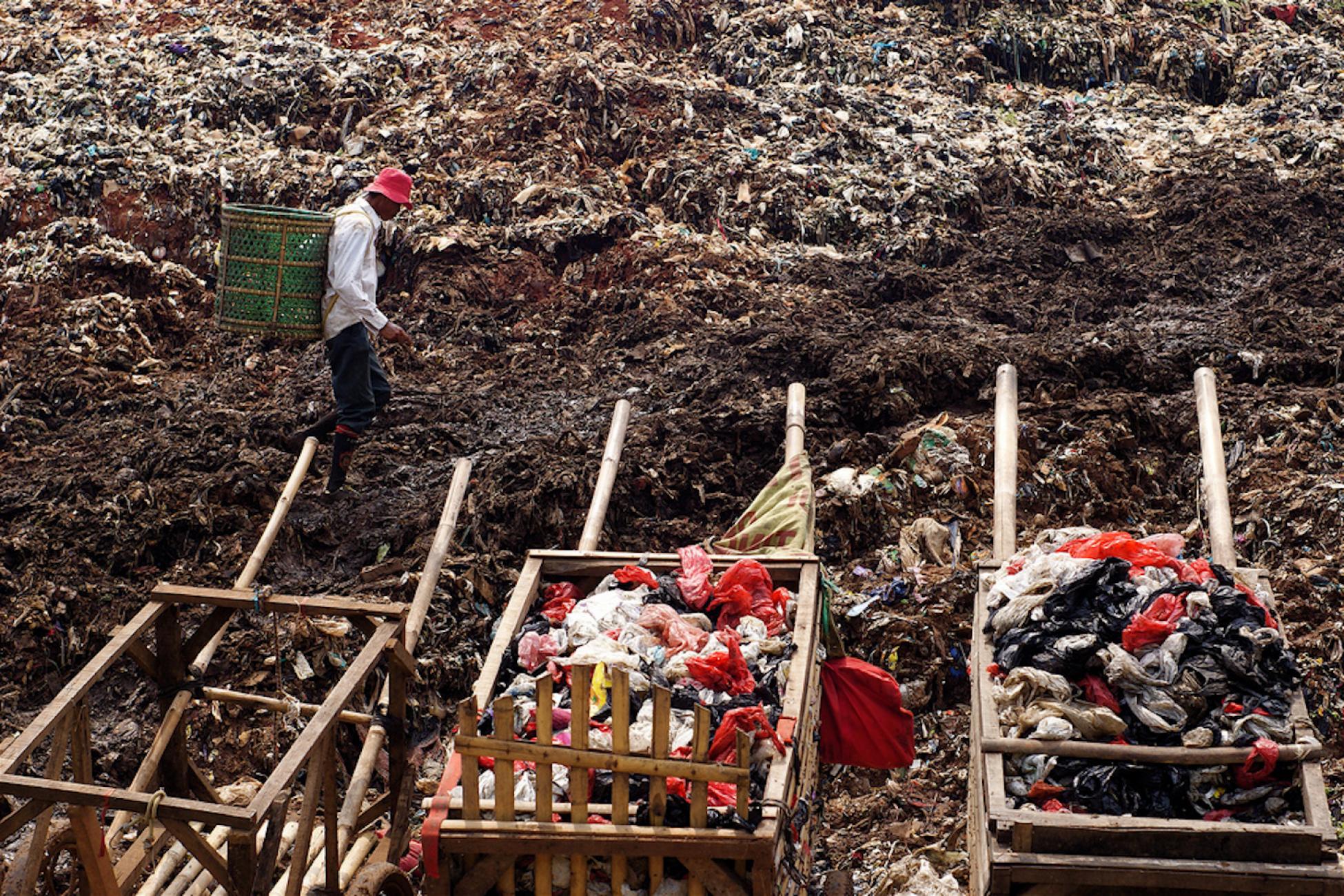 A man walks through an Indonesian dump.