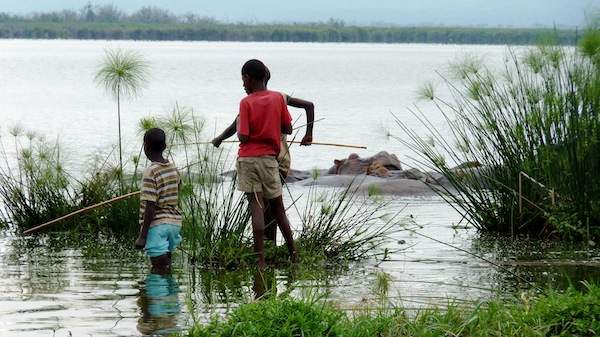 Ugandan boys fish along the edges of Lake Edward.
