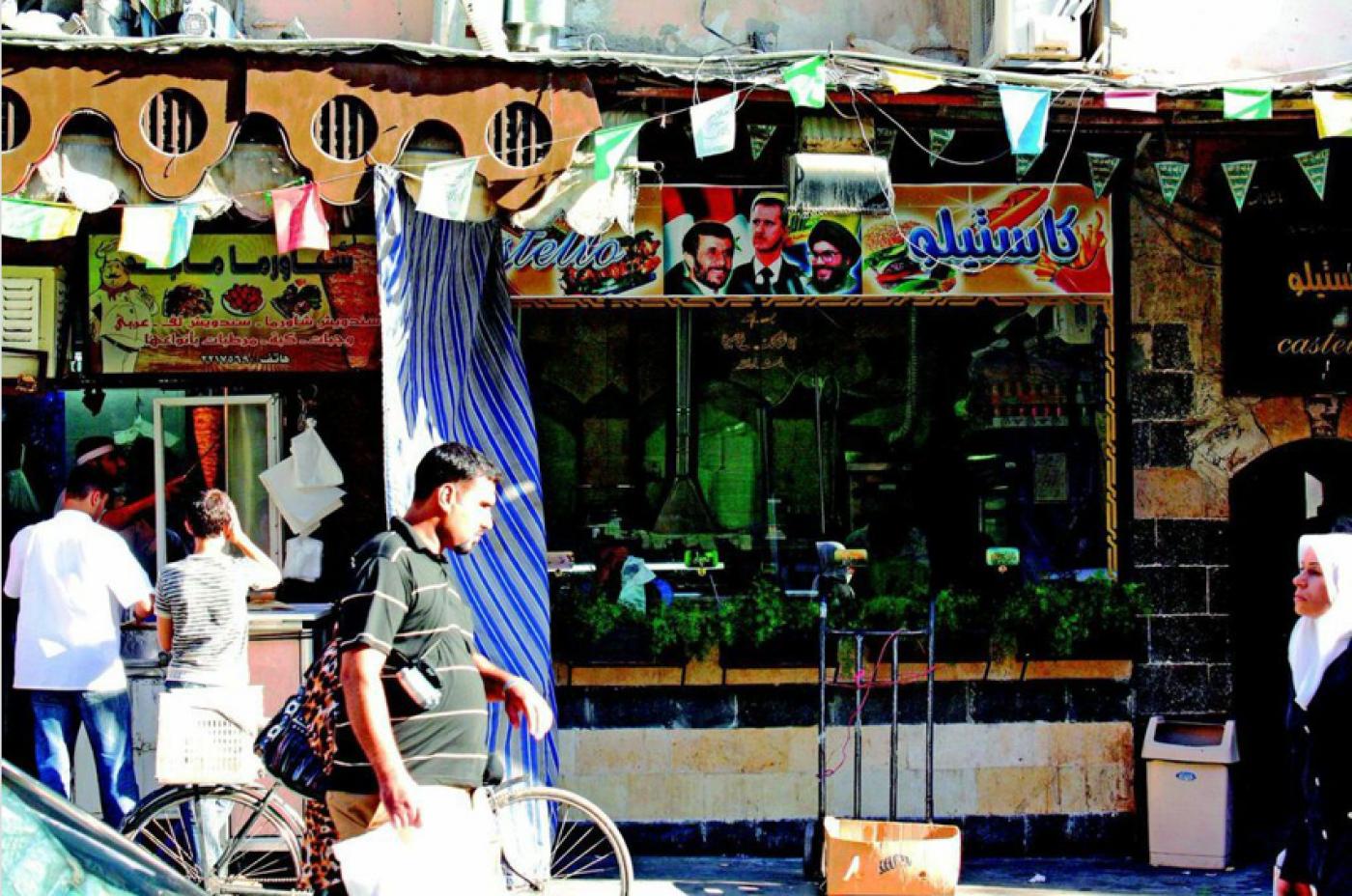 The ubiquitous sign over a shawarma restaurant shows President Mahmoud Ahmadinejad of Iran, President Bashar al Assad of Syria, and Hassan Nasrallah, Secretary General of Hezbollah. Propagandistic photos like this were common around Damascus.